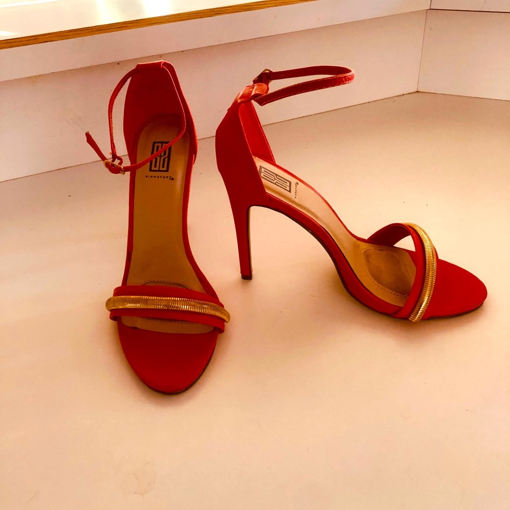 Orange/red high heeled sandal with a gold embellished toe strap. 3.5” heels